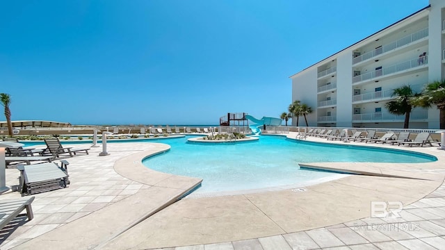 pool featuring a patio area and a water slide