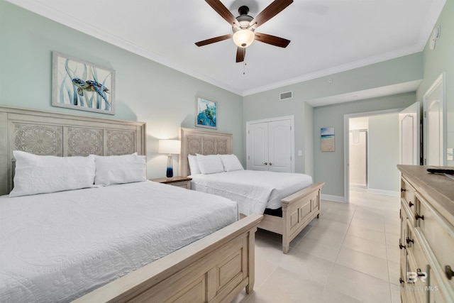 bedroom with light tile patterned floors, visible vents, baseboards, crown molding, and a closet