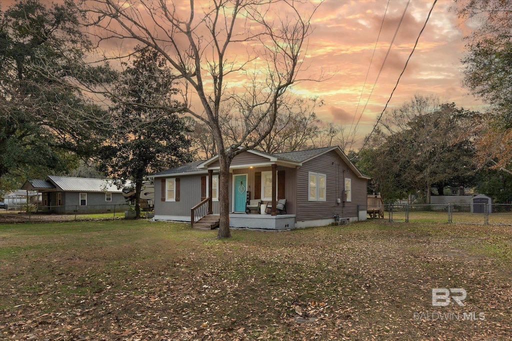 view of front of property with a porch and a lawn