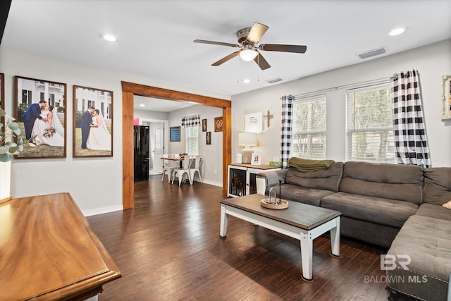 living room with dark hardwood / wood-style flooring and ceiling fan