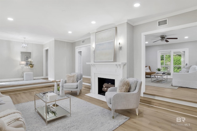300 Indian Creek Dr, Mobile, AL 36607 - living area with a fireplace with flush hearth, crown molding, light wood finished floors, recessed lighting, and a chandelier