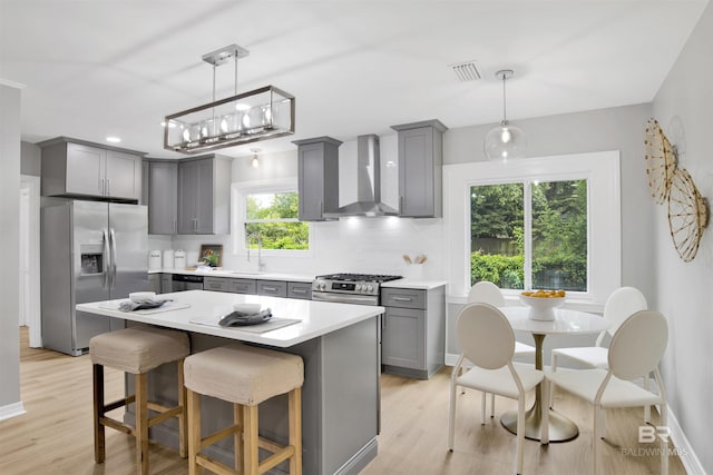300 Indian Creek Dr, Mobile, AL 36607 - kitchen with gray cabinets, appliances with stainless steel finishes, wall chimney exhaust hood, light wood-type flooring, and recessed lighting