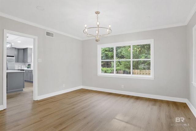 300 Indian Creek Dr, Mobile, AL 36607 - spare room featuring a chandelier, light wood-type flooring, baseboards, and crown molding
