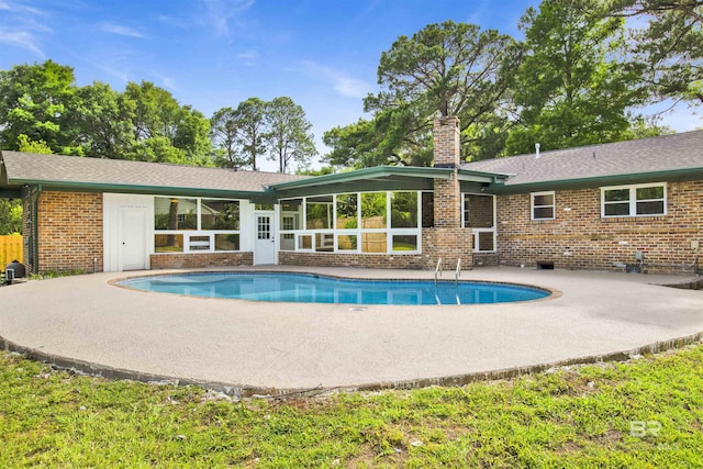 300 Indian Creek Dr, Mobile, AL 36607 - back of property featuring a patio area, an outdoor pool, a chimney, and brick siding