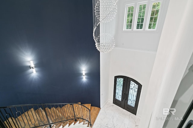 entrance foyer featuring an inviting chandelier and french doors