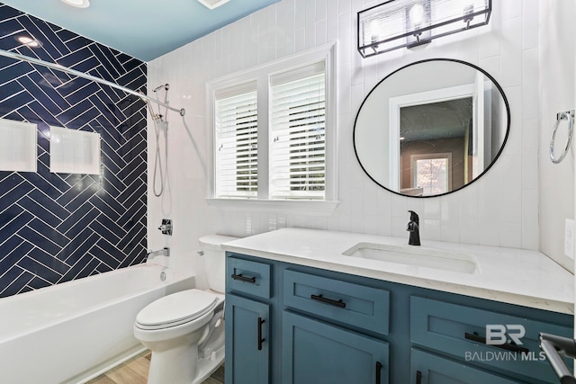 full bathroom featuring tiled shower / bath combo, vanity, tasteful backsplash, wood-type flooring, and toilet