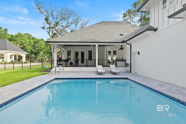 view of pool with a patio, a lawn, french doors, and ceiling fan