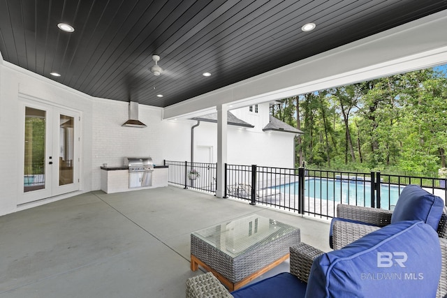 view of patio / terrace featuring french doors, an outdoor kitchen, outdoor lounge area, a grill, and a fenced in pool