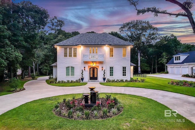 view of front of house with a balcony and a yard