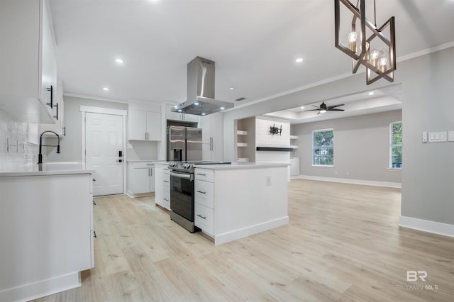 kitchen with appliances with stainless steel finishes, island range hood, white cabinetry, sink, and a center island