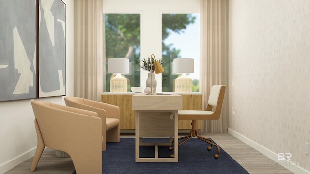 sitting room featuring wallpapered walls, plenty of natural light, baseboards, and wood finished floors