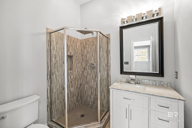 bathroom with toilet, vanity, and walk in shower