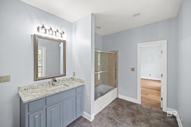 bathroom with combined bath / shower with glass door, vanity, and tile patterned floors