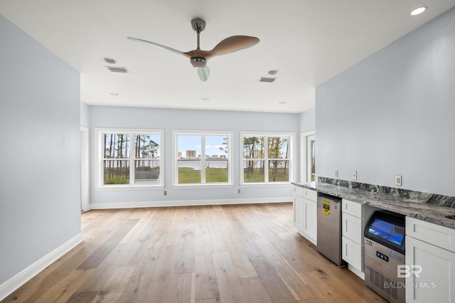 kitchen featuring white cabinetry, stone counters, light hardwood / wood-style floors, and ceiling fan