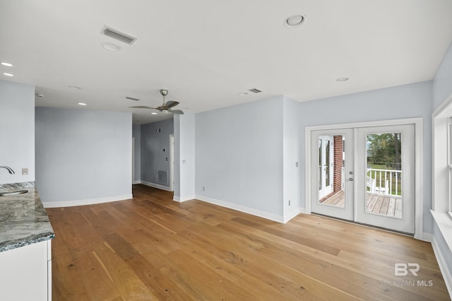 interior space featuring light wood-type flooring, sink, french doors, and ceiling fan