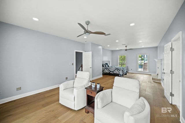 living area with ceiling fan and light wood-type flooring