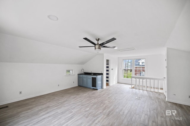 unfurnished living room featuring ceiling fan, light wood-type flooring, and lofted ceiling