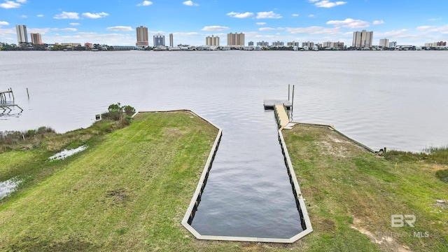 view of dock with a yard and a water view