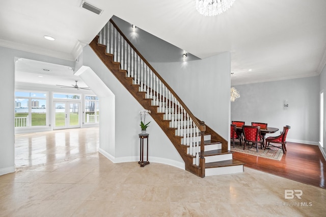 stairs featuring tile patterned flooring, crown molding, and ceiling fan with notable chandelier