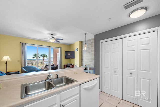 kitchen with light tile patterned floors, white cabinetry, white dishwasher, pendant lighting, and sink