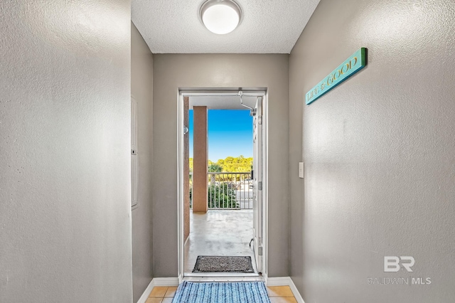 entryway with a textured ceiling and light tile patterned floors