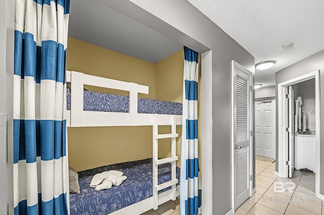 tiled bedroom featuring a closet and a textured ceiling