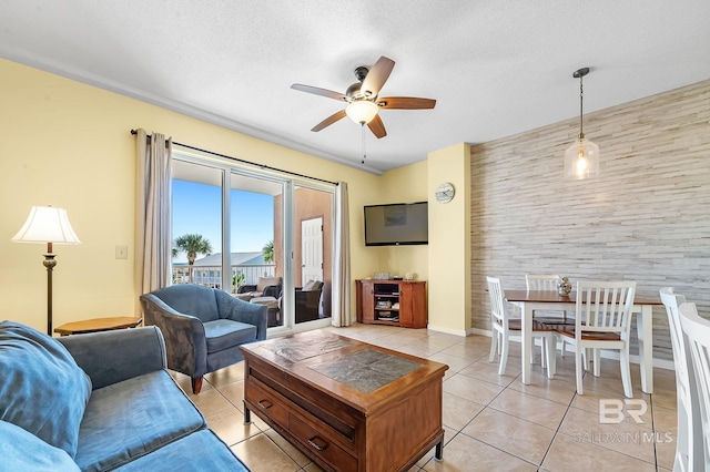 tiled living room with ceiling fan and a textured ceiling