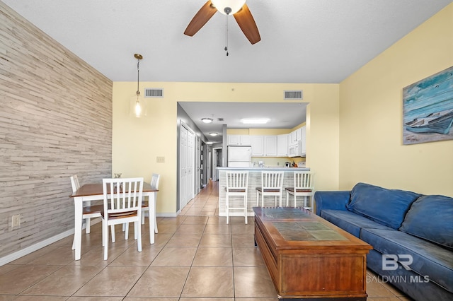 tiled living room featuring a textured ceiling and ceiling fan