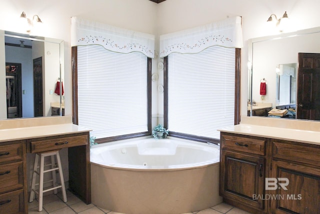 bathroom with tile patterned flooring, a tub, and vanity