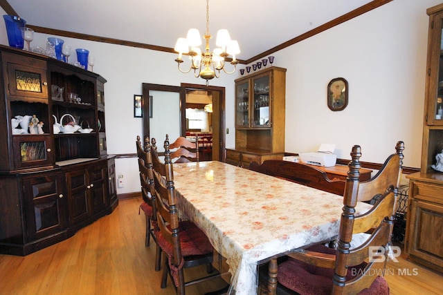 dining room with ornamental molding, light hardwood / wood-style flooring, and a chandelier