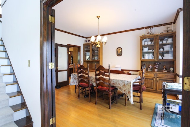 dining room with a chandelier, ornamental molding, and light hardwood / wood-style floors