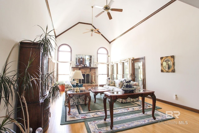 office space featuring a brick fireplace, ceiling fan, light hardwood / wood-style flooring, and high vaulted ceiling