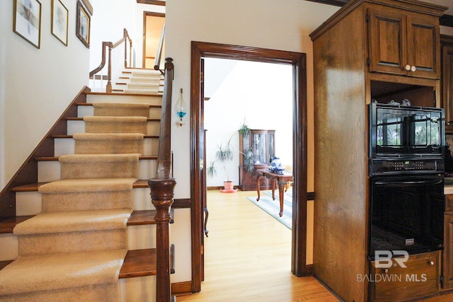 staircase with light hardwood / wood-style floors