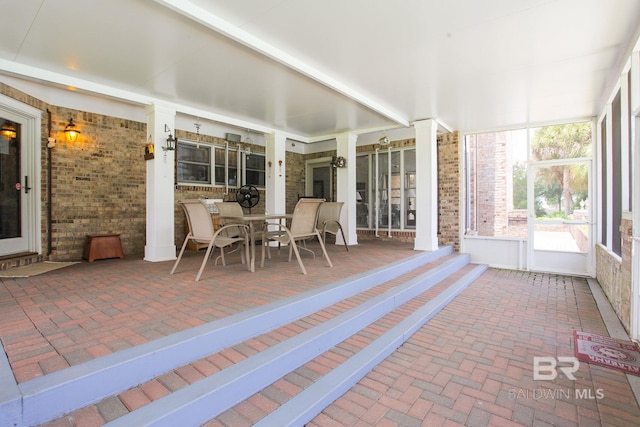 unfurnished sunroom featuring ornate columns