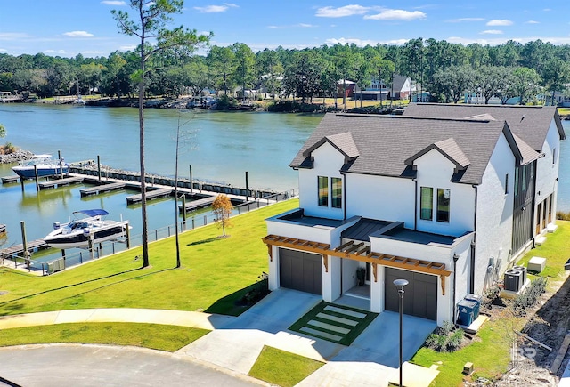 view of front facade featuring a garage, a dock, a water view, and a front lawn