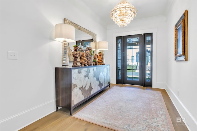 foyer entrance with ornamental molding and hardwood / wood-style flooring