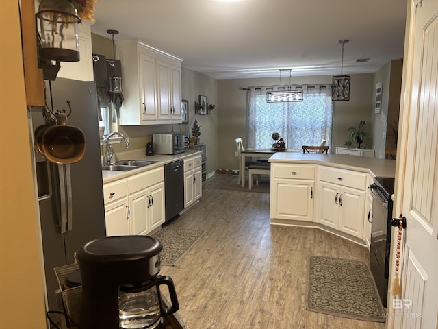 kitchen with white cabinets, hardwood / wood-style floors, black appliances, and sink