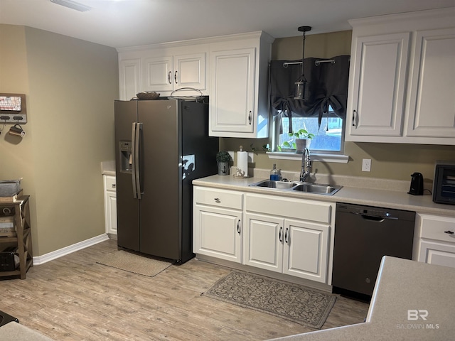 kitchen featuring stainless steel refrigerator with ice dispenser, black dishwasher, white cabinetry, and sink