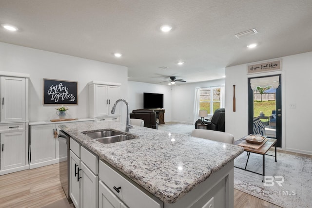 2526 E Windmere Dr, Semmes, AL 36575 - kitchen featuring a sink, a ceiling fan, a kitchen island with sink, stainless steel dishwasher, and light wood-style flooring