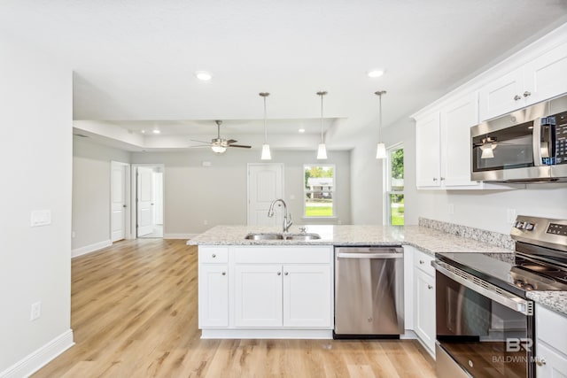 kitchen featuring kitchen peninsula, stainless steel appliances, light hardwood / wood-style floors, and sink