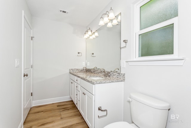 bathroom with hardwood / wood-style floors, vanity, and toilet