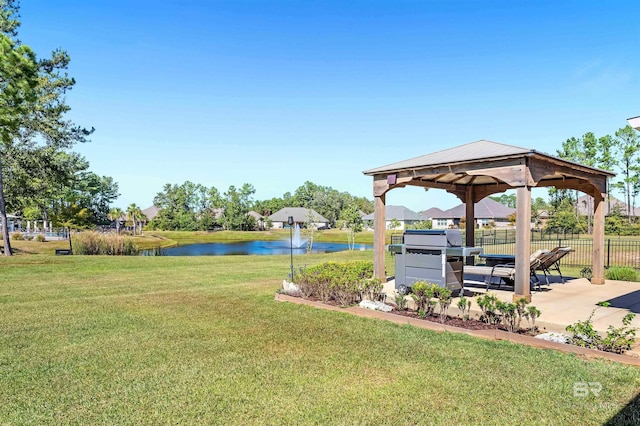 view of property's community featuring fence, a gazebo, a water view, and a lawn