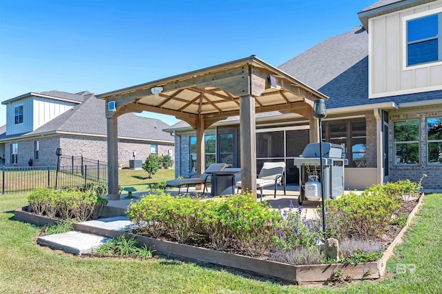 rear view of house featuring a lawn, fence, a gazebo, and roof with shingles