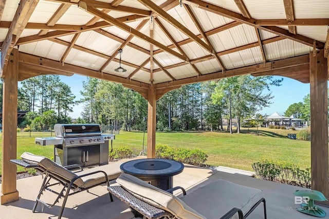 view of patio with area for grilling, a gazebo, fence, and an outdoor fire pit