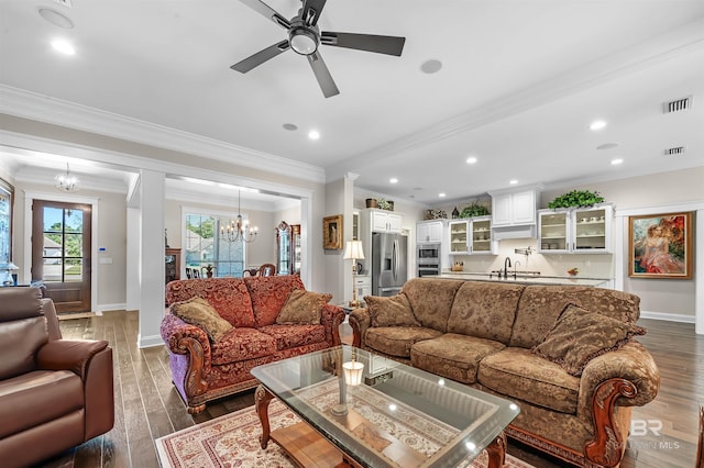 living room featuring visible vents, ceiling fan with notable chandelier, dark wood finished floors, and baseboards