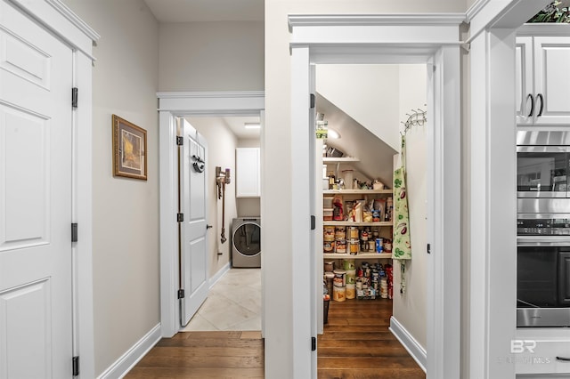 interior space with wood finished floors, washer / clothes dryer, and baseboards