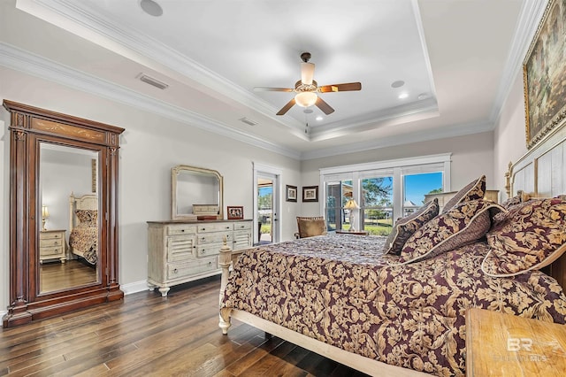 bedroom featuring visible vents, access to outside, dark wood-style flooring, and a tray ceiling