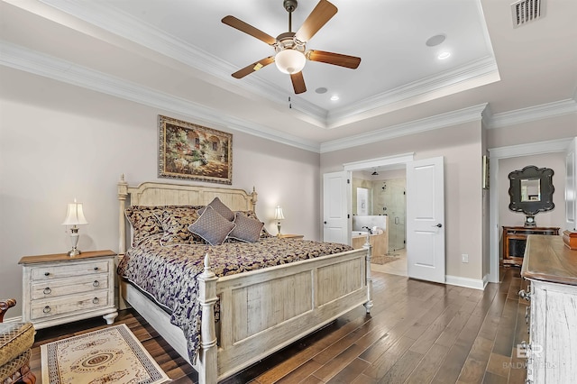 bedroom with dark wood finished floors, visible vents, a raised ceiling, and ornamental molding