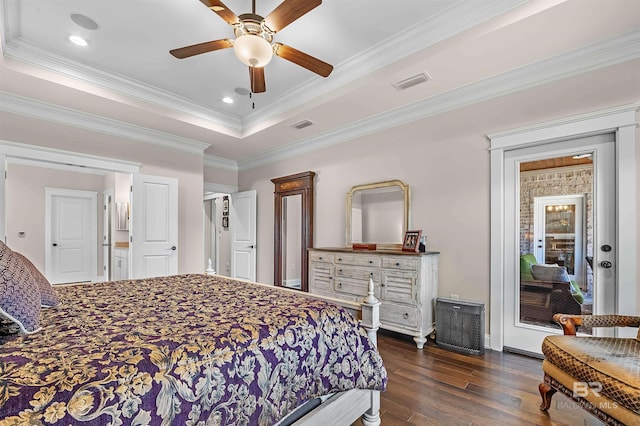 bedroom featuring dark wood-style flooring, access to outside, a tray ceiling, crown molding, and visible vents