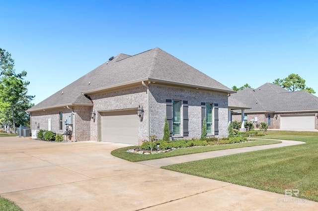 view of front facade featuring a front yard, a shingled roof, central AC unit, driveway, and brick siding